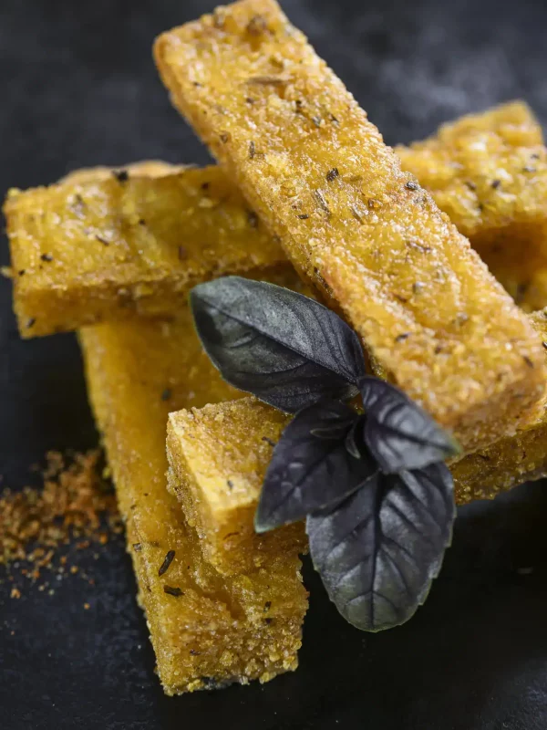 Bâtonnets de polenta croustillants aux herbes, dressés avec du basilic pourpre